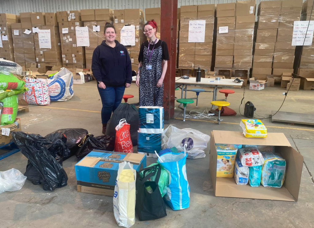 Two students helping at a charity shop