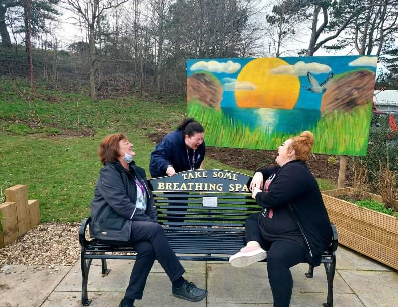 Students laughing - sitting on a bench